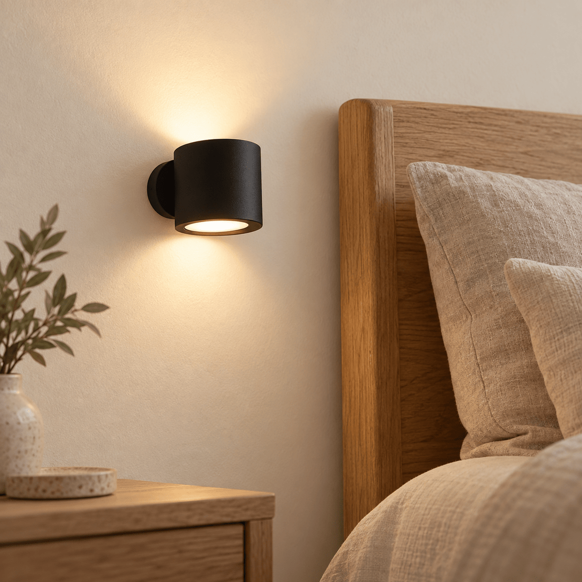 Black magnetic wall light beside a Nordic bed